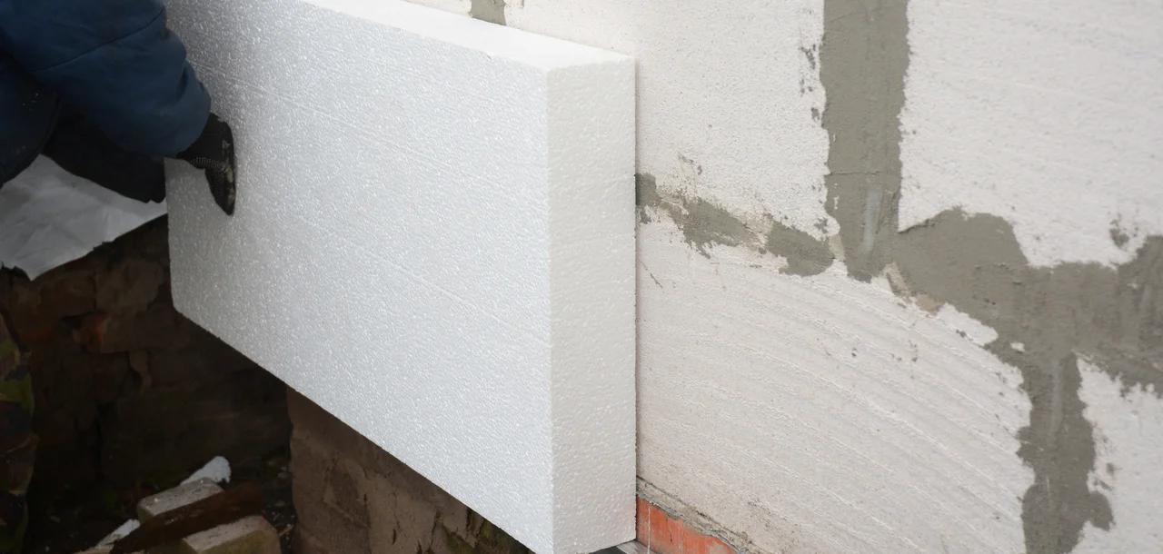 Sockelabschluß - Builder Installation starren Styropor-Dämmplatte zur Energieeinsparung. Starre extrudierten Polystyrol-Dämmung. - Stock-Fotografie